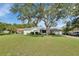 Beautiful curb appeal with lush green lawn and mature trees, complemented by a well-maintained home exterior at 2676 Palm Terrace St, Deland, FL 32720
