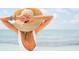 Relaxing Personal wearing hat with ocean backdrop; symbolizing vacation, relaxation, and blissful beachfront living at 2801 Hill St # 801, New Smyrna Beach, FL 32169