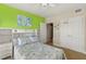 Bedroom featuring bright accent wall, carpet floors, overhead lighting, and built in shelving at 2801 Hill St # 801, New Smyrna Beach, FL 32169