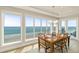 Bright dining room with ocean views from large windows and chandelier lighting at 2801 Hill St # 801, New Smyrna Beach, FL 32169