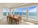 Bright dining room boasting a chandelier, wood table set and panoramic ocean views from large windows at 2801 Hill St # 801, New Smyrna Beach, FL 32169