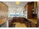 Gourmet kitchen with stainless steel appliances, dark cabinetry, granite counters, and mosaic tile backsplash at 2801 Hill St # 801, New Smyrna Beach, FL 32169