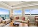 Comfortable living room featuring tile floors, tray ceiling, large windows with ocean views, and modern decor at 2801 Hill St # 801, New Smyrna Beach, FL 32169