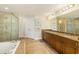 This bathroom features double sinks, a tiled shower, a soaking tub, and a door to a separate room at 2801 Hill St # 801, New Smyrna Beach, FL 32169