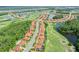 An aerial view of a residential community with tile roofs, lakes, a golf course, and mature trees at 2825 S Asciano Ct, New Smyrna Beach, FL 32168
