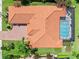 Aerial view of a luxury home with a pool, patio, tiled roof, and manicured lawn at 2825 S Asciano Ct, New Smyrna Beach, FL 32168
