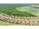 An aerial view of a residential community featuring tile roofs, mature trees, and manicured landscaping at 2825 S Asciano Ct, New Smyrna Beach, FL 32168