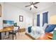 Bright bedroom features a ceiling fan, neutral walls, a desk and beach themed artwork and accessories at 2825 S Asciano Ct, New Smyrna Beach, FL 32168