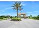 A gated community entrance featuring a guard house, tiled roof, and lush landscaping for added security at 2825 S Asciano Ct, New Smyrna Beach, FL 32168