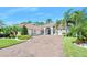 Stunning single-story home featuring a brick driveway, lush landscaping, and a welcoming entrance at 2825 S Asciano Ct, New Smyrna Beach, FL 32168