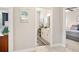 Hallway view looking into a bathroom, featuring white cabinets, gray rug and a picture of New Smyrna Beach at 2825 S Asciano Ct, New Smyrna Beach, FL 32168