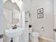 Neat powder room featuring pedestal sink, decorative mirror, and toilet at 2825 S Asciano Ct, New Smyrna Beach, FL 32168