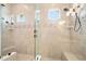 A glass enclosed shower features tile walls, built-in bench, and a mosaic tile accent stripe, and dual shower heads at 2825 S Asciano Ct, New Smyrna Beach, FL 32168