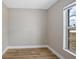 Cozy bedroom featuring wood-look flooring, baseboard trim, neutral colors, and a sunlit window at 2831 Fifer Dr, Deltona, FL 32738