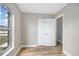 Neutral bedroom with a closet, wood-look flooring, baseboard trim, and a bright window view at 2831 Fifer Dr, Deltona, FL 32738