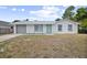 Charming single-story home with a gray garage door, white exterior, and bright blue front door at 2831 Fifer Dr, Deltona, FL 32738