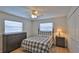 Well-lit bedroom with a ceiling fan, a dresser, and two windows with blinds at 2970 Lantern Dr, South Daytona, FL 32119