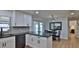Well-lit kitchen showcasing modern white cabinetry, black appliances, and black countertops at 2970 Lantern Dr, South Daytona, FL 32119