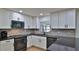 Modern kitchen featuring white cabinets, black hardware, and stainless steel appliances at 2970 Lantern Dr, South Daytona, FL 32119