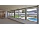 View from sunroom looking out to fenced backyard with pool, dining space, and landscaping at 2970 Lantern Dr, South Daytona, FL 32119