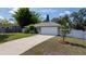 A one-story house with well-maintained lawn, long driveway, and a two-car garage at 3013 Hunkin Cir, Deltona, FL 32738