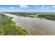 Aerial photo overlooking the river, lined with vibrant coastal foliage and community residences at 317 River Front Way, Edgewater, FL 32141
