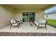 Cozy back patio area with outdoor seating, and a sliding glass door at 317 River Front Way, Edgewater, FL 32141