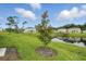 Backyard shot of a community pond, featuring a young tree and lush green grass at 317 River Front Way, Edgewater, FL 32141