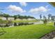 Lush backyard view showcasing a tranquil pond with a fountain and neighboring houses at 317 River Front Way, Edgewater, FL 32141