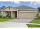 Inviting single-Gathering home with a two-car garage, a cozy front porch and manicured landscaping at 317 River Front Way, Edgewater, FL 32141