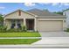 Charming single-Gathering home with a two-car garage, front porch and manicured lawn and garden at 317 River Front Way, Edgewater, FL 32141
