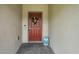 Inviting front door adorned with a colorful wreath, and a decorative blue stool at 317 River Front Way, Edgewater, FL 32141
