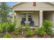Welcoming front porch with seating area and charming decor surrounded by lush landscaping at 317 River Front Way, Edgewater, FL 32141