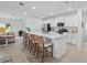 Open-concept kitchen with a large island, barstool seating, sleek white cabinets, and stainless steel appliances at 317 River Front Way, Edgewater, FL 32141