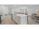 Bright kitchen features a large island with white cabinets, stainless steel appliances, and an open concept layout at 317 River Front Way, Edgewater, FL 32141