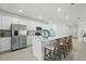 Modern white kitchen with stainless steel appliances, a large island with bar seating, and ample cabinet space at 317 River Front Way, Edgewater, FL 32141
