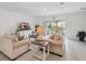 Cozy living room with neutral furniture, large windows, and access to the backyard at 317 River Front Way, Edgewater, FL 32141