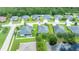 Aerial view of a single-Gathering home with a well-manicured lawn and mature trees backing up to a pond at 32 Abacus Ave, Ormond Beach, FL 32174