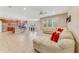 Spacious living room features tile flooring, modern ceiling fan, lots of light, and open view to kitchen at 32 Abacus Ave, Ormond Beach, FL 32174