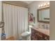Clean bathroom with a shower and tub, wood vanity, decorative mirror, and warm lighting at 3324 Royal Palm Dr, Edgewater, FL 32141