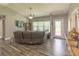Comfortable living room with vaulted ceiling, ceiling fan, wood-look flooring, and large windows for ample natural light at 3324 Royal Palm Dr, Edgewater, FL 32141