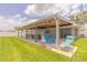 Large covered patio with stylish seating, an outdoor kitchen, and beautiful views at 3324 Royal Palm Dr, Edgewater, FL 32141