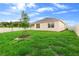 Expansive backyard featuring a well-maintained lawn, white fence, and young trees, offering privacy and space at 33436 Shutterfly Way, Sorrento, FL 32776