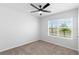 Cozy bedroom featuring a ceiling fan and a large window offering a pleasant view of the outdoors at 33436 Shutterfly Way, Sorrento, FL 32776