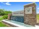 The Sorrento Pines community sign features a stone facade and a water feature at 33436 Shutterfly Way, Sorrento, FL 32776