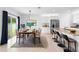 Open-concept dining area with modern lighting and easy access to the kitchen and outdoor patio at 33436 Shutterfly Way, Sorrento, FL 32776
