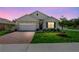 Charming single-story home featuring a well-manicured lawn, brick driveway, and blue shutters at 33436 Shutterfly Way, Sorrento, FL 32776