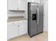 Close-up of stainless steel refrigerator and white cabinets in a modern kitchen at 33436 Shutterfly Way, Sorrento, FL 32776