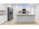 Modern kitchen with stainless steel appliances, white cabinets, and a center island at 33436 Shutterfly Way, Sorrento, FL 32776