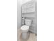 Close-up of a toilet with white overhead shelving for bathroom storage solutions at 33436 Shutterfly Way, Sorrento, FL 32776